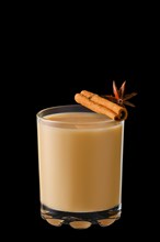 Hot milk winter drink with cinnamon and anise isolated on black