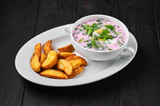 Cold beet soup with potato wedges on a plate