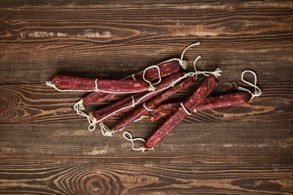 Overhead view of sun dried pork sausages on wooden background
