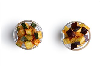 Fried square chips made of aubergine and zucchini in round glass plates isolated on white