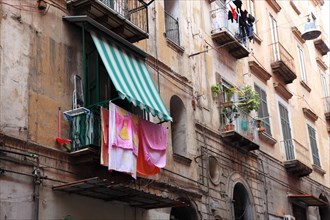 Laundry drying on the line on the wall of a morbid apartment building in the old town of Naples