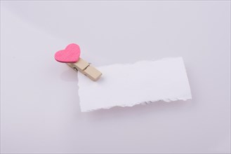 Pink hearted clip on a white note paper