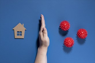 Flat lay hand protecting house from viruses