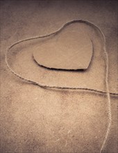 Thread off spool form a heart shape on brown background