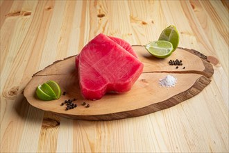 Fresh raw tuna steak on wooden cutting board