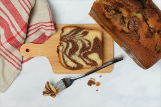 Marble cake on wooden board and fork
