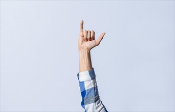 Hand gesturing the letter Y in sign language on an isolated background. Man's hand gesturing the letter Y of the alphabet isolated. Letter Y of the alphabet in sign language