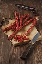 Air dried deer and pork sausage on wooden background