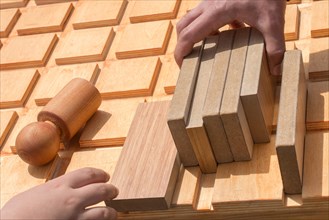 Hand holding wooden puzzle element in hand