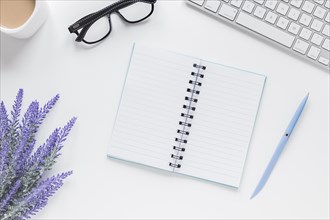 Opened notebook near lavender keyboard glasses desk