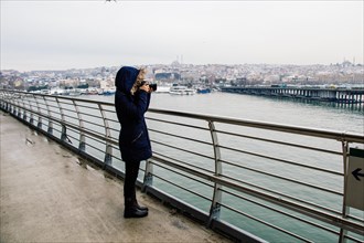 Tourist girl photographer with dslr camera outdoor on the bridge in Golden Horn