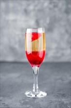 Strawberry cocktail with sparcling wine on gray shabby background