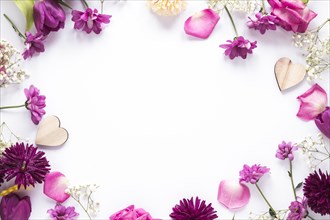 Different flowers with wooden hearts table