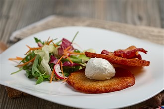 Classic potato pancakes with bacon and salad. Soft focus photo
