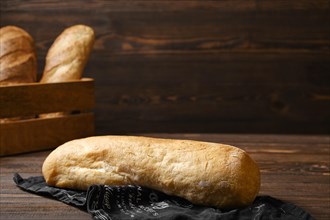 Freshly baked ciabatta on brown wooden table