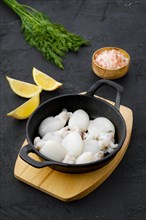 Baby cuttlefish in cast iron skillet with dill