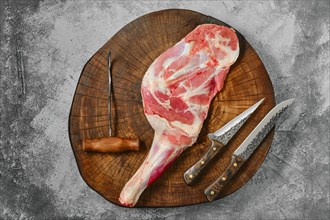 Raw fresh lamb shoulder chump on butcher's cutting log