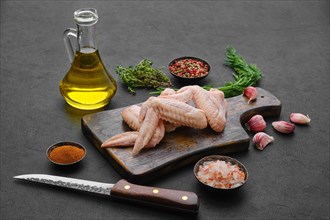 Fresh uncooked chicken wings on wooden cutting board ready for cooking