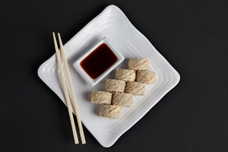 Top view of chicken teriyaki roll with soy sauce and hashi