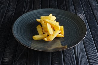 Portion of fried potato on dark wooden table