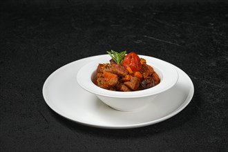Beef stew with tomato on a plate