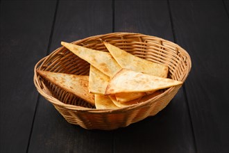 Tortilla cut on triangular slices in wicker backet on a table
