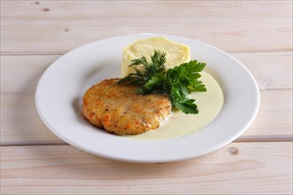 Fish cutlet with mashed potato on wooden table