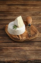Brie cheese or camembert on woden board with knife for soft cheese