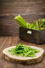 Fresh peas in a pod on wooden cutting board