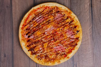 Top view of pizza with ham and balsamic sauce cutted on pieces