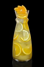 Decanter with orange and lemon lemonade isolated on black