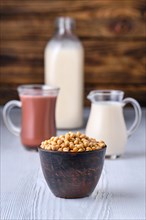 Chocolate milk and soy milk in glass on white table over dark wooden background