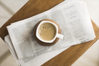 Mug with hot coffee newspapers