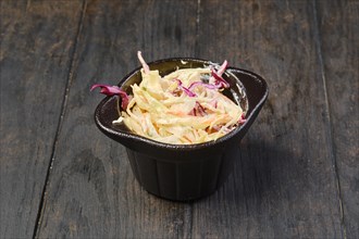Bowl with colorful cabbage salad on a table