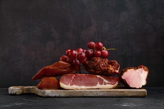 Wooden cutting board with assortment of pork ham