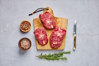 Overhead view of raw fresh deer neck with spice and herb over concrete background