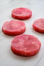 Fresh raw round tuna cutlet on wooden background