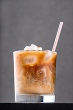 Iced coffee with cream on dark wooden table