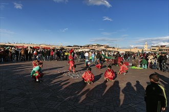 Acrobats in traditional dress in the bustling marketplace Djemaa el Fna