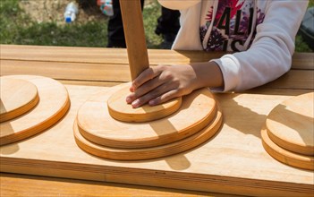 Hand holding wooden puzzle element in hand