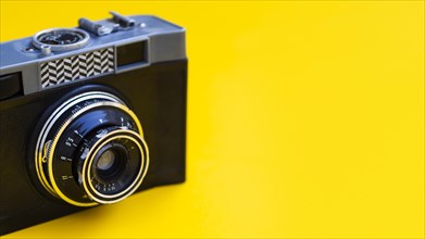 Close up vintage photo camera with yellow background
