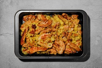 Chicken stripes baked with cheese and onion in oven-tray