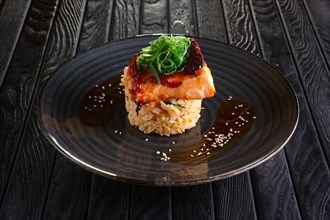 Roasted salmon with rice and spices decorated with seaweed