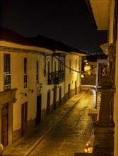 View from hotel balcony of cobblestone alley at night