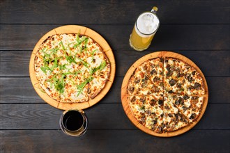 Top view of a table with two pizzas and glass of wine and beer