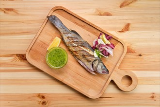 Whole fried fish on wooden board