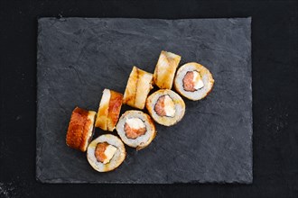 Rolls with eel and cream cheese on slate plate