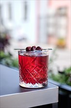 Cherry cocktail on the edge of the table on outdoor terrace