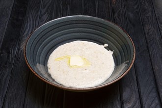 Plate with oatmeal and piece of butter