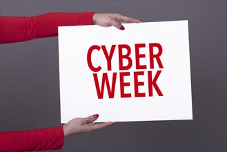 Female hands holding a cyber week poster. Studio shot